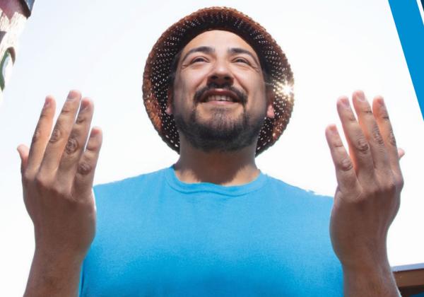 Man in the Indigenous thank-you pose with hands raised. 